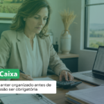 Contadora analisa documentos e usa uma calculadora ao lado do notebook, em escritório com vista para o campo. Texto: “Livro Caixa: por que manter organizado antes de a transmissão ser obrigatória”.