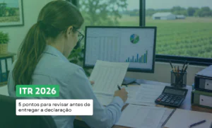 Mulher contadora, de costas, analisa documentos em frente ao computador, em um escritório com vista para uma área rural. Sobre a imagem, aparece o texto: “ITR 2026: 5 pontos para revisar antes de entregar a declaração”.